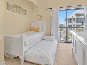 a bedroom with two beds and a balcony at Seagrove Dunes #1 in Seagrove Beach
