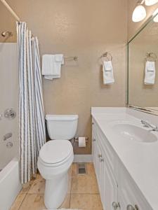 a bathroom with a toilet and a sink and a shower at Seagrove Dunes #1 in Seagrove Beach +27 photos