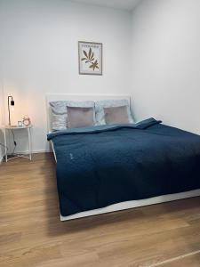 a bedroom with a bed with a blue comforter at Apartment ARTIC I Cityblick & Komfort in Nordhorn