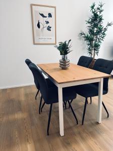 een eettafel met stoelen en een vaas erop bij Apartment Artic I - im Stadtzentrum in Nordhorn