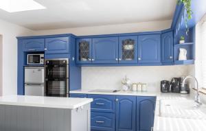 een keuken met blauwe kasten en witte aanrechtbladen bij GuestReady - Charming house in Drimnagh in Dublin