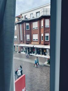 een groep mensen die door een straat voor een gebouw lopen bij Apartment Artic I - im Stadtzentrum in Nordhorn