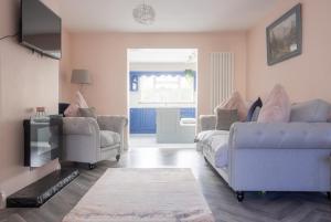 een woonkamer met een bank en 2 stoelen bij GuestReady - Charming house in Drimnagh in Dublin