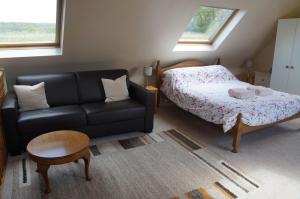 a living room with a couch and a bed at Burraton Cob in Exeter