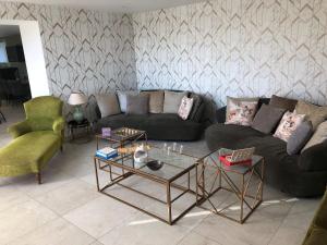 uma sala de estar com um sofá e duas cadeiras em Maison des Bruyères 25pers jacuzzi, billard baby em Le Bény-Bocage
