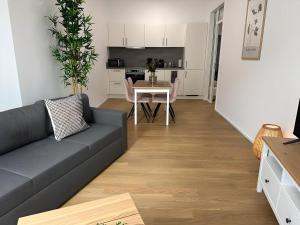 a living room with a couch and a table at Apartment ARTIC II Ausblick & Citylage in Nordhorn