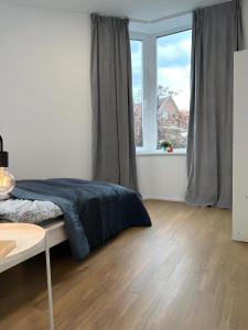 a bedroom with a bed and a large window at Apartment Artic III - im Stadtzentrum in Nordhorn