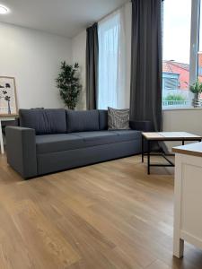 - un salon avec un canapé bleu et une table dans l'établissement Apartment Artic III - im Stadtzentrum, à Nordhorn