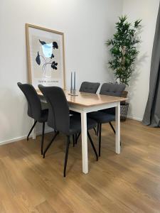 a dining room table with four chairs and a plant at Apartment Artic III - im Stadtzentrum in Nordhorn