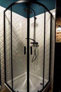 a shower with a glass door in a bathroom at Apartamenty Nowa Ruda in Nowa Ruda