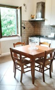 casa di arya CODICE CITRA LT-0043 في Vescina: طاولة وكراسي خشبية في مطبخ