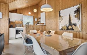 a kitchen and dining room with a large wooden table and chairs at Lovely Home In Ebeltoft With Swimming Pool in Ebeltoft