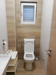 a small bathroom with a toilet and a window at Beachfront apartments Pag in Pag +40 photos