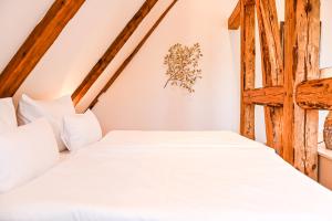 a bedroom with a bed with white sheets at Jagdschloss Friedrichsmoor in Neustadt-Glewe