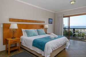 a bedroom with a bed with a view of the ocean at Sugar Beach Resort in Elysium +22 photos