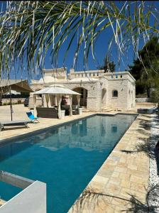 a swimming pool in front of a house at Villa Brachychiton in Ostuni