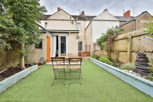 a patio with a table and chairs on the grass at StayRight Stunning 2 Bedroom Apartment Close to City Centre & Bay in Cardiff