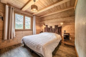 a bedroom in a log cabin with a bed at Chalet le Ber Abbay in Abondance