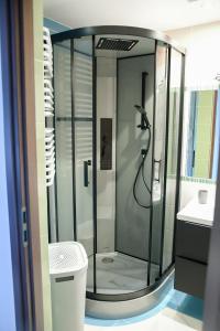 a glass shower in a bathroom with a sink at Apartament Nad Zalewem in Zamość