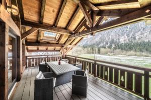 een veranda met een tafel en stoelen op een terras bij Chalet le Ber Abbay in Abondance