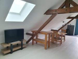 Una sala de estar con televisión, mesa y sillas. en Appartement cosy proche centre, en Colmar