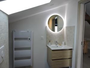 un baño con lavabo y espejo en Appartement cosy proche centre, en Colmar 15 fotos más