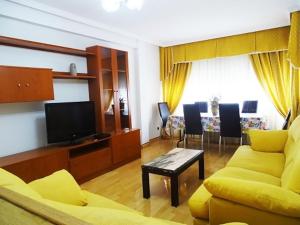 uma sala de estar com um sofá amarelo e uma televisão em Apartamento En Alcalá De Henares em Alcalá de Henares