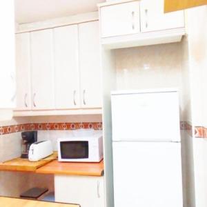 a kitchen with a white refrigerator and a microwave at Apartamento En Alcalá De Henares in Alcalá de Henares