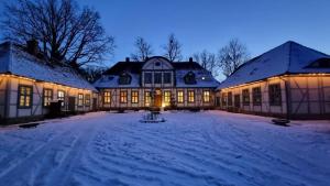 a large house in the snow at night at Jagdschloss Friedrichsmoor in Neustadt-Glewe