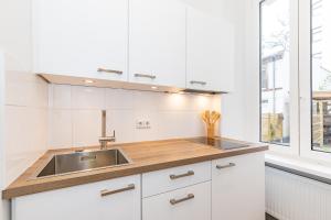 a white kitchen with a sink and a window at Cosy Apartment Berlin Neukölln in Berlin