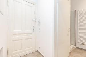 a white door in a room with a shower at Cosy Apartment Berlin Neukölln in Berlin