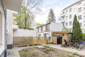 a backyard with a wooden fence and some bikes at Cosy Apartment Berlin Neukölln in Berlin