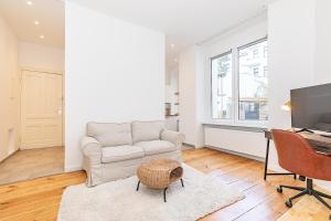 a living room with a couch and a desk with a computer at Cosy Apartment Berlin Neukölln in Berlin
