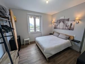 a small bedroom with a bed and a ladder at Logis Hôtel Restaurant SPA le Beau Site in Chambon-sur-Lac