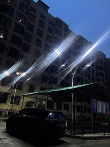 samochód zaparkowany przed budynkiem z oświetleniem w obiekcie Уютная квартира в центре города w Samarkandzie