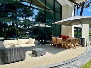 a patio with a couch and a table with an umbrella at BelArt Luxury Golf Villa in Aroeira