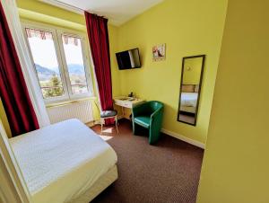 a hotel room with a bed and a desk and a mirror at Logis Hôtel Le Beau Site in Chambon-sur-Lac