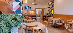 a restaurant with tables and chairs and a tv at Hotel Vilagarcia in Vilagarcia de Arousa