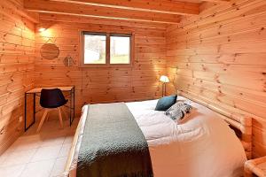 a bedroom with a bed in a wooden cabin at Chalet Bois Cosy - Climatisé - Piscine privée in Ferdrupt +13 photos