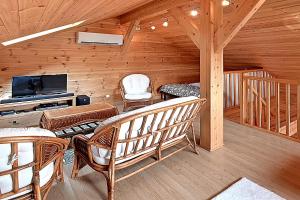 ein Wohnzimmer mit Stühlen und einem TV in einer Hütte in der Unterkunft Chalet Bois Cosy - Climatisé - Piscine privée in Ferdrupt