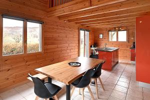 ein hölzernes Esszimmer mit einem Holztisch und Stühlen in der Unterkunft Chalet Bois Cosy - Climatisé - Piscine privée in Ferdrupt