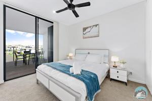 a bedroom with a bed and a balcony at Aircabin - Shell Cove - Waterview - 2 Bed Apt in Shellharbour