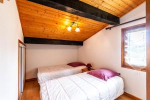 - 2 lits dans une chambre dotée d'un plafond en bois dans l'établissement Le Magy - Appt vue montagne proche station de ski, aux Gets