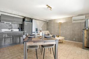 a kitchen and dining room with a table and chairs at Appart Rez de jardin vue mer in Cavalaire-sur-Mer +25 photos