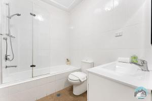 uma casa de banho com um WC, um chuveiro e um lavatório. em Aircabin - North Ryde - Sydney - 4 Beds House em Sydney