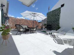a patio with chairs and a table with an umbrella at Apartment Olive in Kaštela