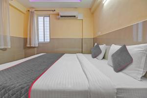 um quarto com uma grande cama branca com almofadas em Super Townhouse 1266 Empire Executive em Pune