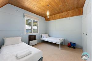 um quarto com uma cama e um banco em Aircabin - Oberon - Great Location - Comfy Chalet em Oberon