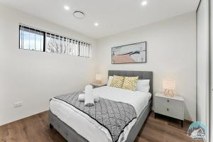 a white bedroom with a bed and a window at Aircabin - Kingswood - Sydney - 3 Beds Townhouse in Kingswood