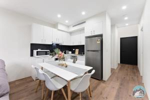 a kitchen with a table and chairs and a refrigerator at Aircabin - Kingswood - Sydney - 3 Beds Townhouse in Kingswood